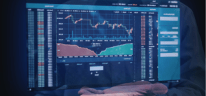 A hand holding a tablet displaying financial and data charts